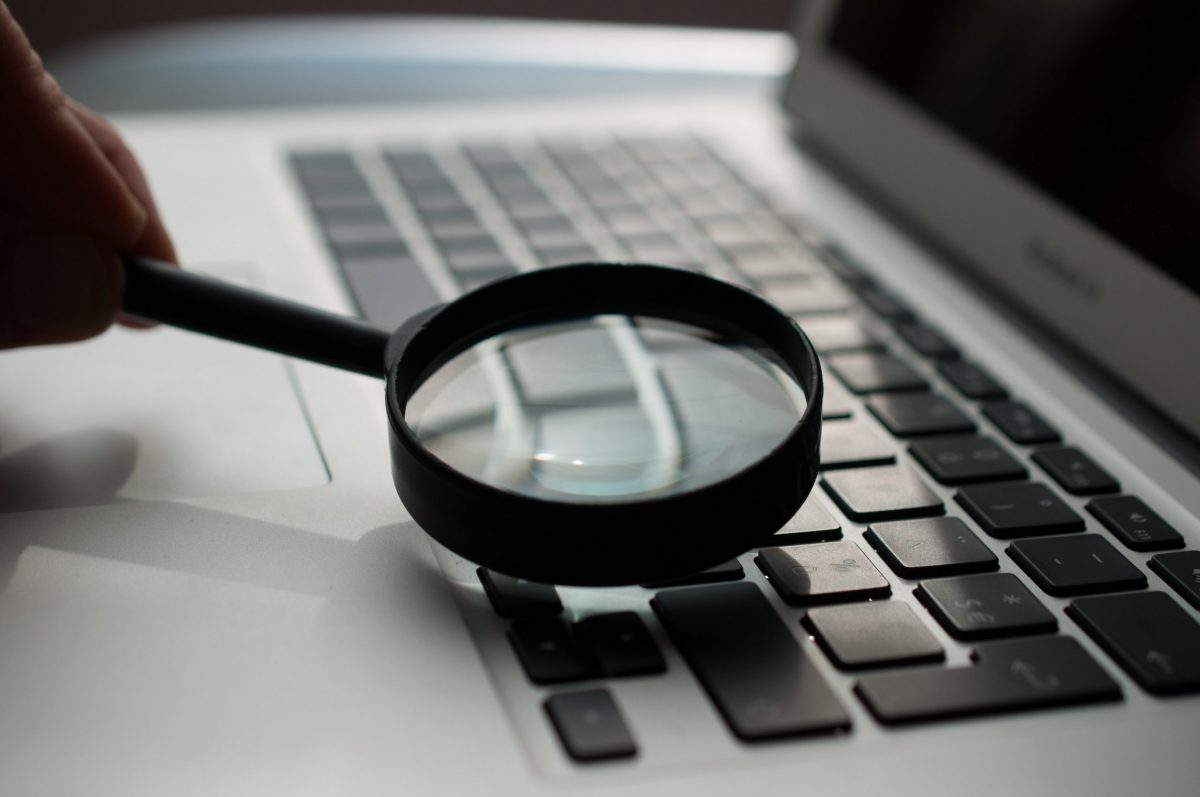 magnifying glass held over laptop keyboard